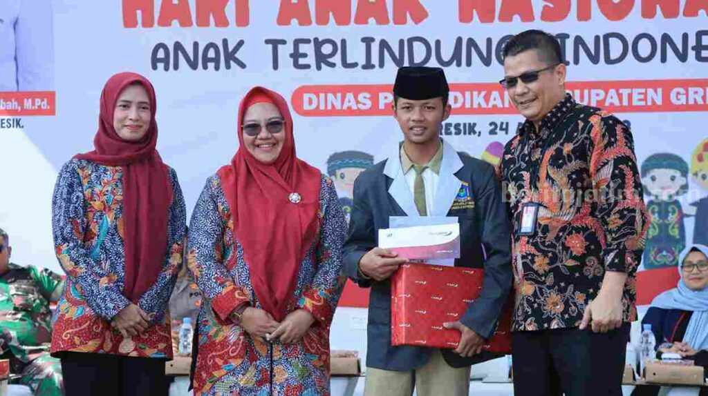 Pelajar MA Al Ibrohimi Gresik Sakha Ardiansyah (pakai peci) saat menerima hadiah laptop