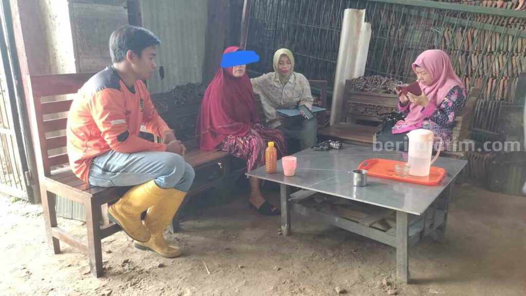 AL (46) memakai kerudung merah usai melakukan aksi percobaan bunuh diri di Jalan Raya Desa Sambiroto, Kecamatan Sooko, Kabupaten Mojokerto. [Foto : ist]