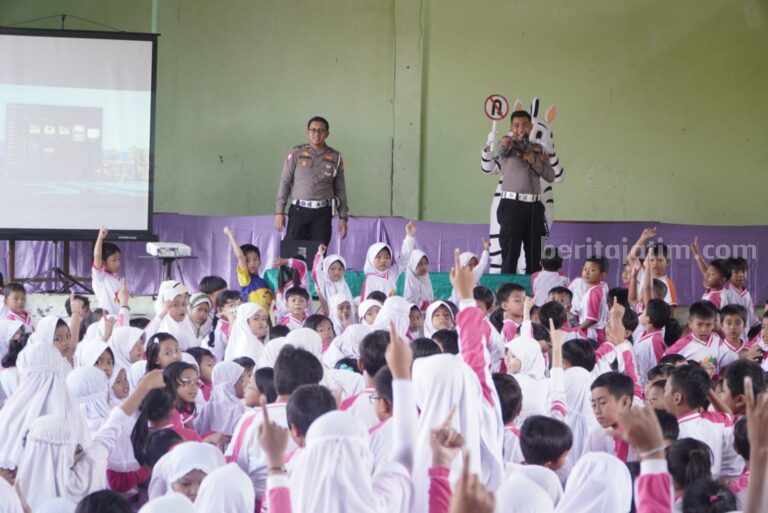Foto dua anggota polisi saat memberikan edukasi berlalu lintas dihadapan siswa sekolah dasar