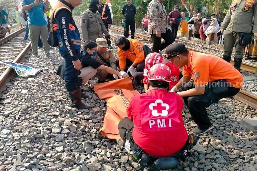 Petugas gabungan BPBD Kota Surabaya dan PMI Kota Surabaya ketika mengevakuasi jenazah bocah kelas 6 SD yang tersambar kereta api di Sememi, Selasa (29/08/2023).