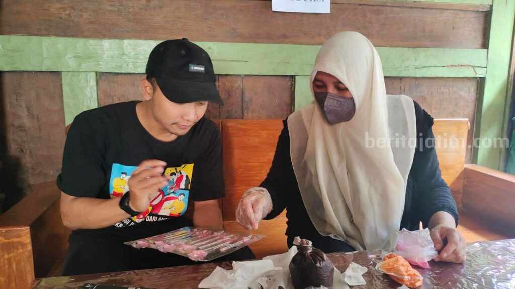 Denok Winarni bersama pembeli saat membuat lukisan cokelat karakter. [Foto:Diah Ayu/beritajatim.com]