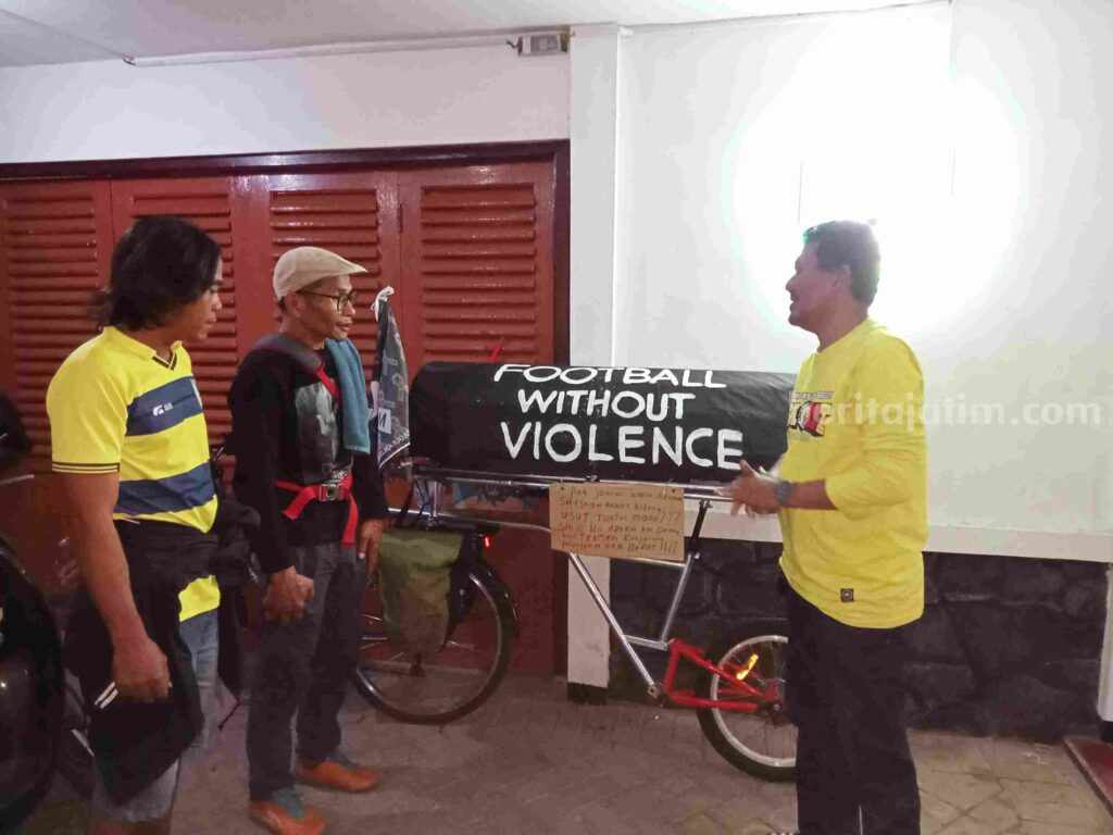 Midun (dua dari kiri) dengan membawa sepeda onthel dipasangi keranda hitam didampingi dua suporter Ultras di kantor sekretariat Gresik United