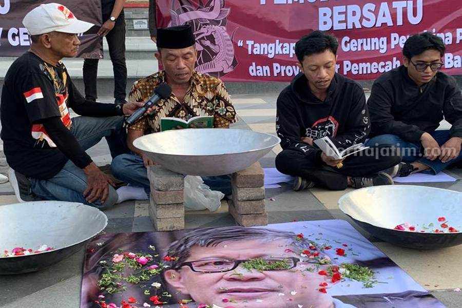 Dianggap Hina Jokowi, Pemuda Surabaya Bersatu Bacakan Yasin untuk Rocky Gerung Kusnan Hadi saat membacakan Surat Yasin di deoan Gedung Grahadi, Kamis (03/08/2023). (Foto/Anggadia).