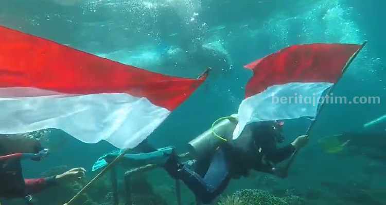 Penyelam yang mengibarkan bendera Merah Putih.