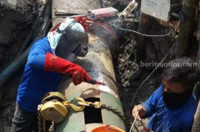 Karyawan proyek sedang memasang pipa induk untuk melayani sambungan rumah baru di wilayah Duduksampeyan Gresik.