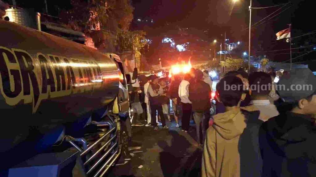 Truk tangki nopol S 9085 UP muatan air mineral menjadi tontonan warga. [Foto: tin]