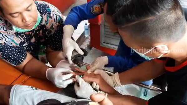 Petugas Damkar Kota Mojokerto menangani pelepasan cincin dari jari manis Harianto (69) warga Desa Jatipasar, Kecamatan Trowulan, Kabupaten Mojokerto. [Foto : Misti/beritajatim.com]