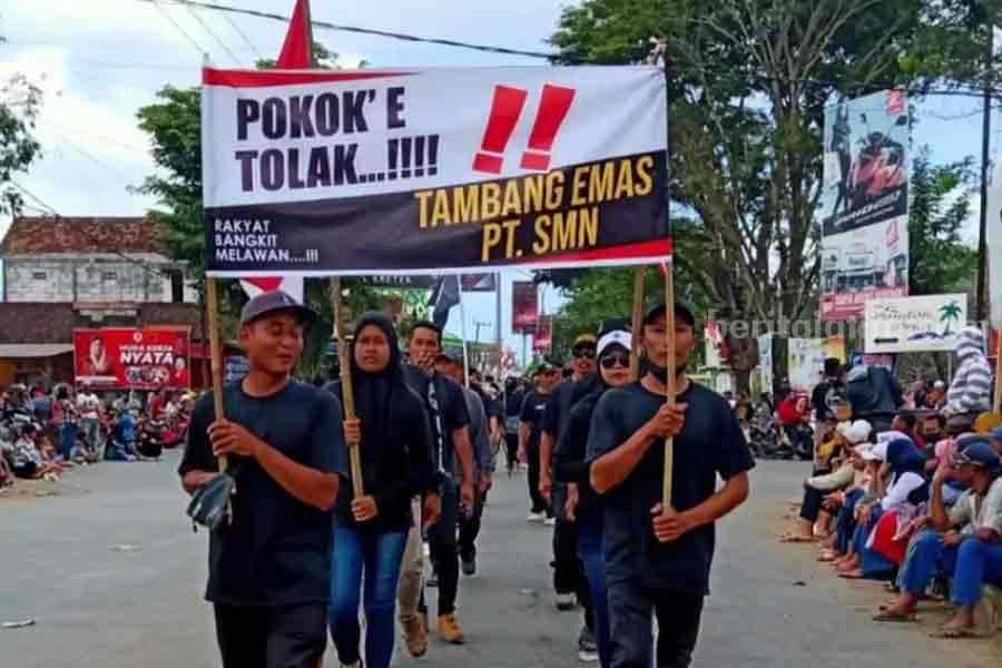 Pawai di Trenggalek Jadi Ajang Warga Tolak Tambang Emas: POKO’E TOLAK!!! Desa Dukuh, Kecamatan Watulimo, Kabupaten Trenggalek ikuti pawai kebudayaan dengan poster penolakan tambang emas.