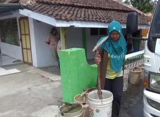Soleha, warga Desa Manduro Kecamatan Kabuh Kabupaten Jombang sedang memikul dua ember berisi air bersih, Kamis (3/8/2023)
