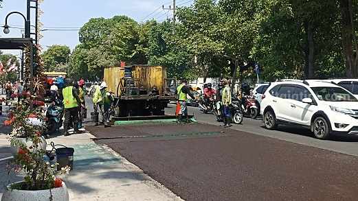 Pelapisan menggunakan teknologi 'slurry seal" di Jl KH Wahid Hasyim Jombang, Jumat (11/8/2023)