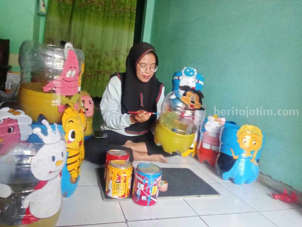 Ifta Farika (27) saat mengerjakan pesanan pot bunga di rumahnya di Dusun Merjoyo RT 02 RW 03, Desa Jatipasar, Kecamatan Trowulan, Kabupaten Mojokerto. [Foto : ist]
