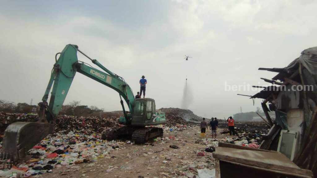Petugas melakukan pembasahan melalui water booming helikoper BNPB di TPA Randegan, Kelurahan Kedundung, Kecamatan Magersari, Kota Mojokerto. [Foto : ist]