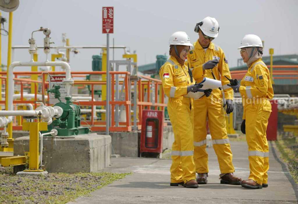 Petronas Tuntaskan Pengalihan Hak Partisipasi Wilayah Kerja Ketapang Tiga karyawan Petronas sedang mengecek di area onshore