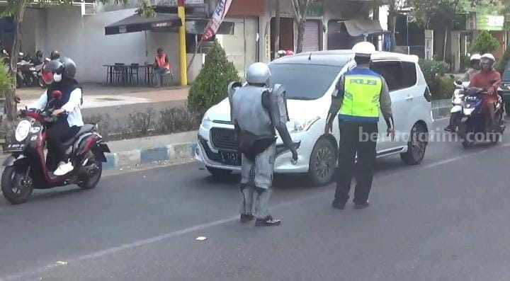 Polisi berpakaian Robocop di jalan raya Bangkalan, tegur penguna jalan raya tanpa menggunakan helm (Foto: Zamachsari/beritajatim.com)