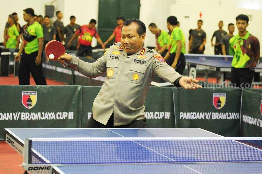 Kapolda Jawa Timur, Irjen Pol Toni Harmanto menunjukan kepiawaian bermain pingpong di Kejuaraan Tenis Meja Piala Pangdam V Brawijaya 2023. (Foto/Julian Romadhon for Beritajatim.com)