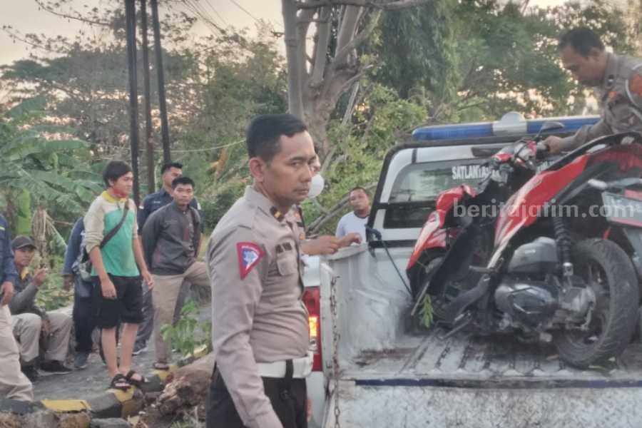 Polisi saat mengevakuasi motor mikik wanita yang meninggalnkarena tertimpa pohon tumbang di Jalan Ring Road Barat Kota Madiun, Kamis (21/9/2023).