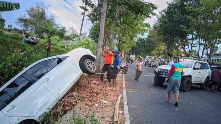 Petugas mengevakuasi mobil Toyota Calya Nopol L 1699 J dari dalam parit. [Foto : ist]