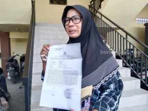 Rofiah Lapor Dugaan Penculikan Anak ke Polres Sampang Rofiah saat menunjukan surat laporan dugaan penculikan anak ke Polres Sampang (Foto: Zamachsari/beritajatim.com)