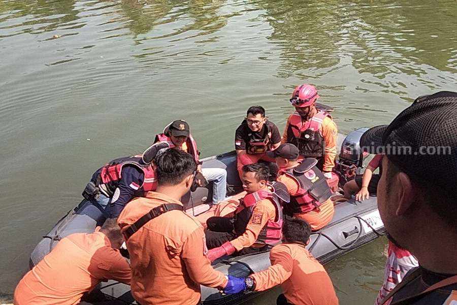 Petugas BPBD Surabaya saat mengevakuasi jenazah Happy di sungai Karah, Jalan Gunungsari, Kamis (21/09/2023). (Foto/Anggadia).