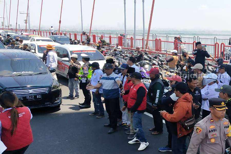 Ormas Madas Tutup Akses Tol Suramadu Massa aksi ketika menutup jalur mobil di jembatan Suramadu, Senin (25/09/2023). (Foto/anggadia).