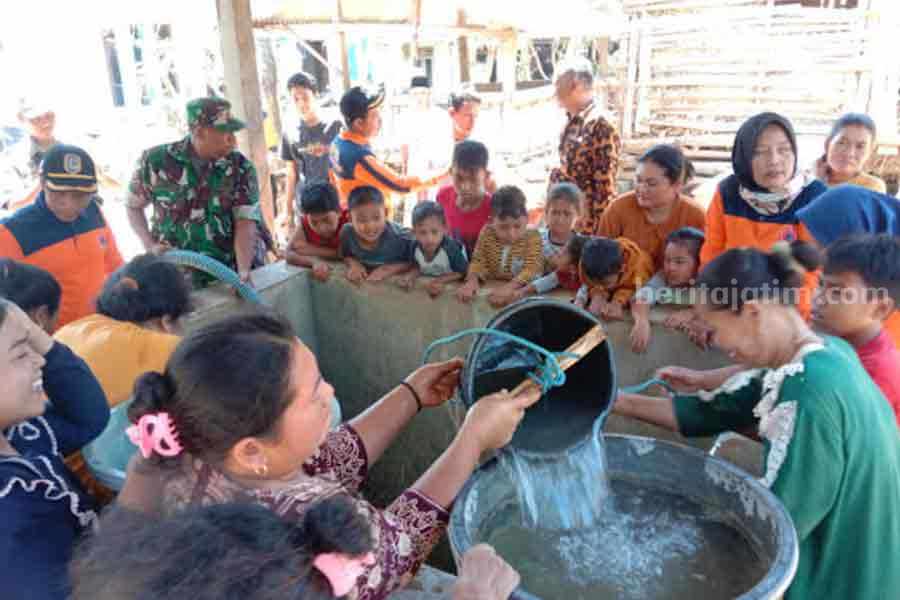 Warga Desa Sumurgung, Kecamatan Montong, Kabupaten Tuban yang sangat antusias mengambil droping air bersih. Foto:Diah Ayu/beritajatim.com]