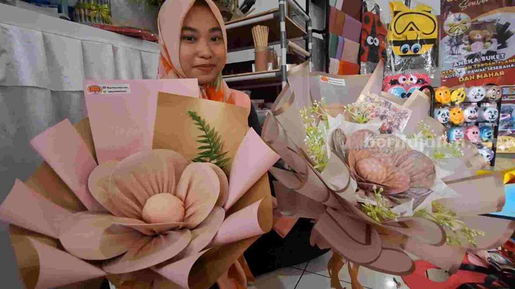Gita Gowinda Soedharmo (31) mengerjakan pesanan buket hujab di rumahnya di Jalan Masjid No 36 RT 6 RW 2, Kelurahan Mojosari, Kecamatan Mojosari, Kabupaten Mojokerto. [Foto : Misti/beritajatim.com] 