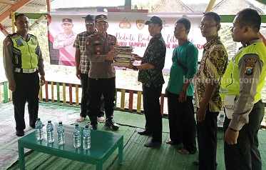 Kapolsek Mojoagung, Kompol Bambang Setyobudi, menyerahkan buku bacaan kepada Ketua Taman Baca BBM, Jumat (1/9/2023)
