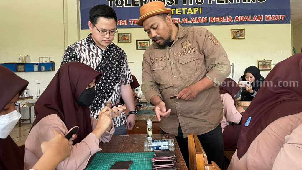 Siswa SMKN 12 Surabaya antusias mengolah limbah kulit sapi jenis smooth grain jadi sejumlah merchandise pameran.