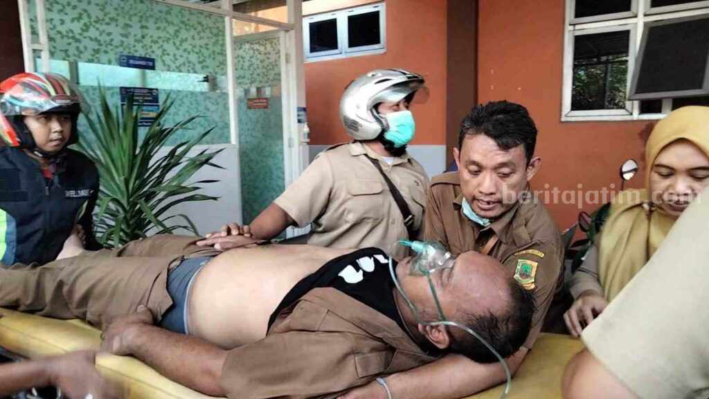 Salah satu tenaga honorer Diskominfo Kota Mojokerto saat dievakuasi ke mobil ambulance. [Foto : Misti/beritajatim.com]