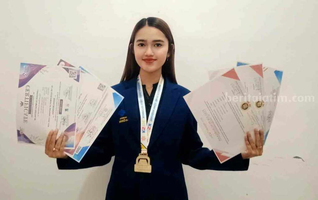 Regina Diah Mahasiswa Berprestasi Ma Chung dengan Raihan Juara di Berbagai Bidang Regina menunjukkan sertifikat berbagai prestasi yang telah diraihnya (Foto: Istimewa)