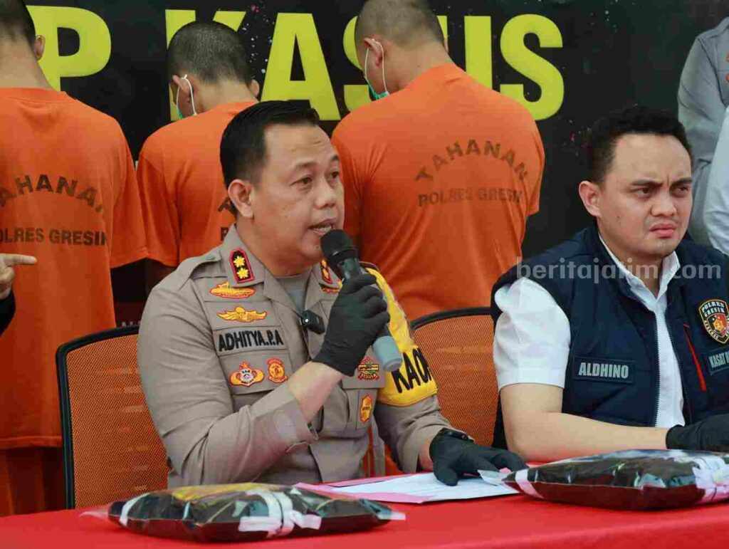 Keroyok Juniornya, 6 Pesilat Asal Gresik Terancam Pidana 12 Tahun Penjara Kapolres Gresik AKBP Adhitya Panji Anom didampingi Kasatreskrim AKP Aldhino Prima Wirdhan saat menjelaskan kasus pengeroyokan yang menyebabkan satu pesilat meninggal dunia