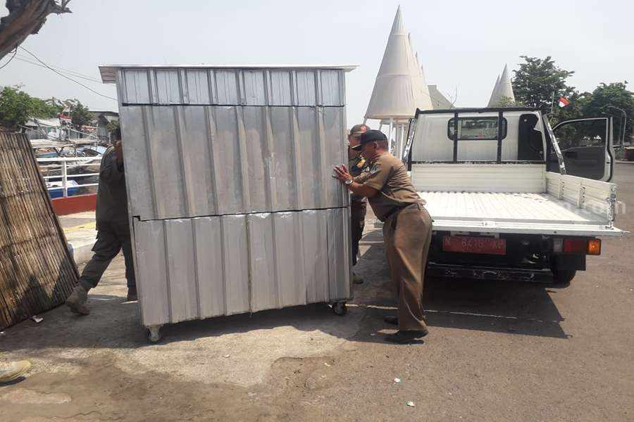 Petugas Satpol PP Kota Pasuruan saat mengankut tempat PKL di wilayah Pelabuhan Pasuruan.