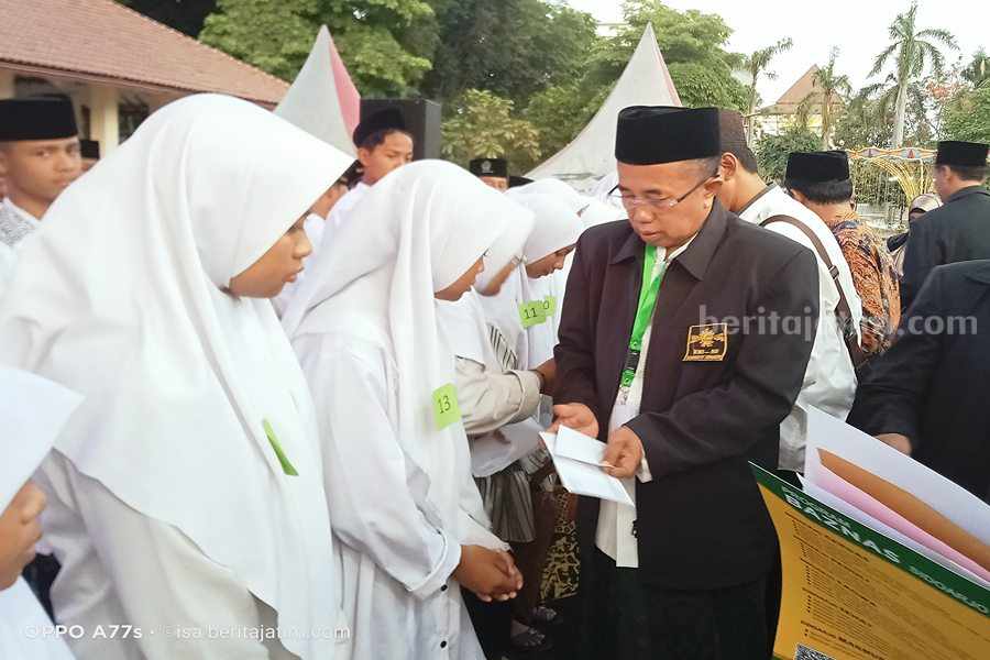 Ketua RMINU Sidoarjo KH M Ahmad Syakir Ridho menyerahkan santunan ke santri putri
