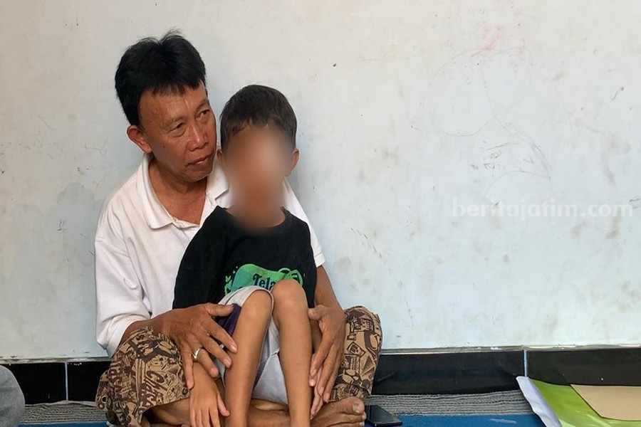 Dwi Santoso duduk dipangkuan bapaknya Sumawan. (Foto/Istimewa)