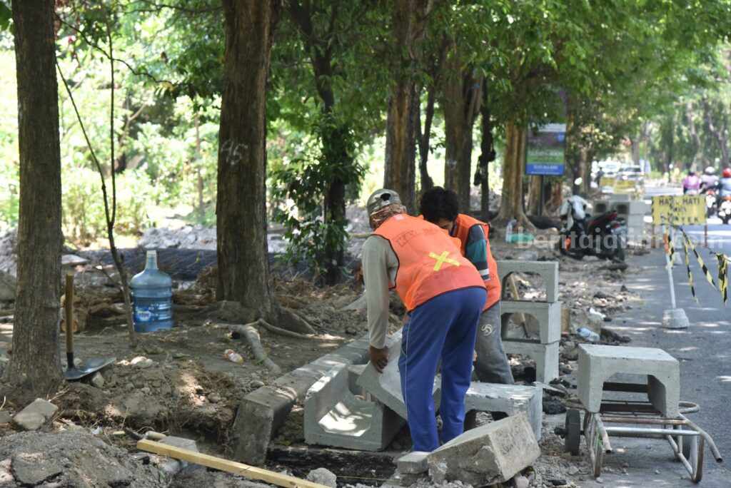 Pekerja proyek beraktifitas di trotoar Jalan Lingkar Barat