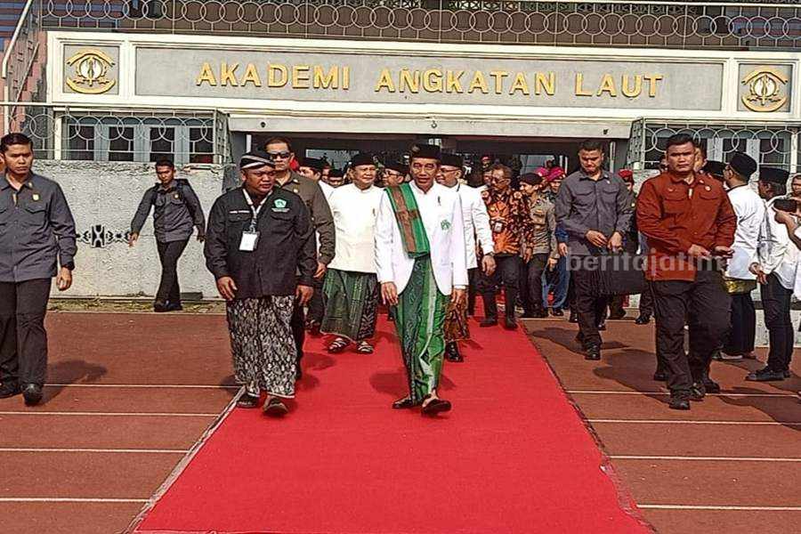 Presiden Jokowi (hem putih) didampingi oleh Ketua Umum Pimpinan Pusat (PP) Pagar Nusa M Nabil Haroen (baju hitam) saat tiba di lapangan Jala Krida Mandala, Bumimoro, Surabaya, Minggu (22/10/2023). (Foto/Anggadia)