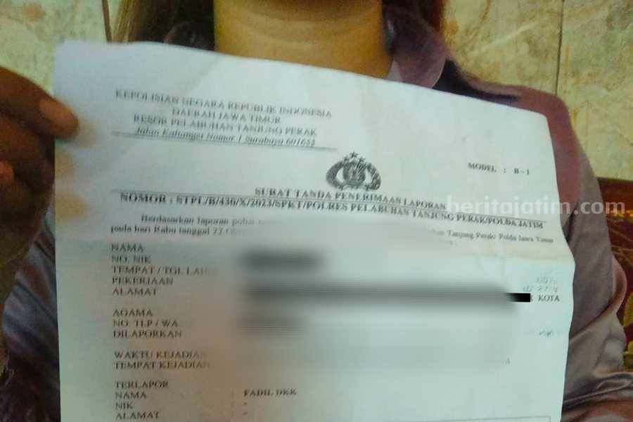 Korban AH saat menunjukan bukti laporan di Polres Pelabuhan Tanjung Perak.