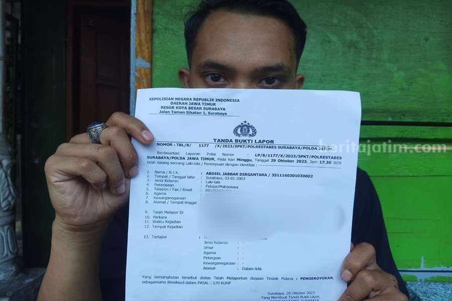 AJ (20) Korban pengeroyokan kelompok silat di Surabaya saat menunjukan bukti laporan di Polrestabes Surabaya.