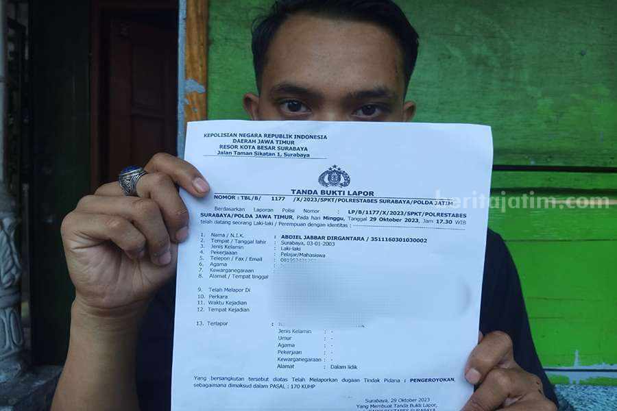 Korban AJ (20) menunjukan surat laporan pengeroyokan oleh oknum pesilat di Surabaya. (Foto/anggadia).
