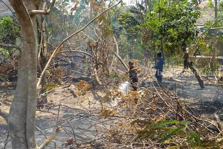 Petugas berusaha memadamkan api yang membakar lahan di Jalan Menur. (Foto/Istimewa)