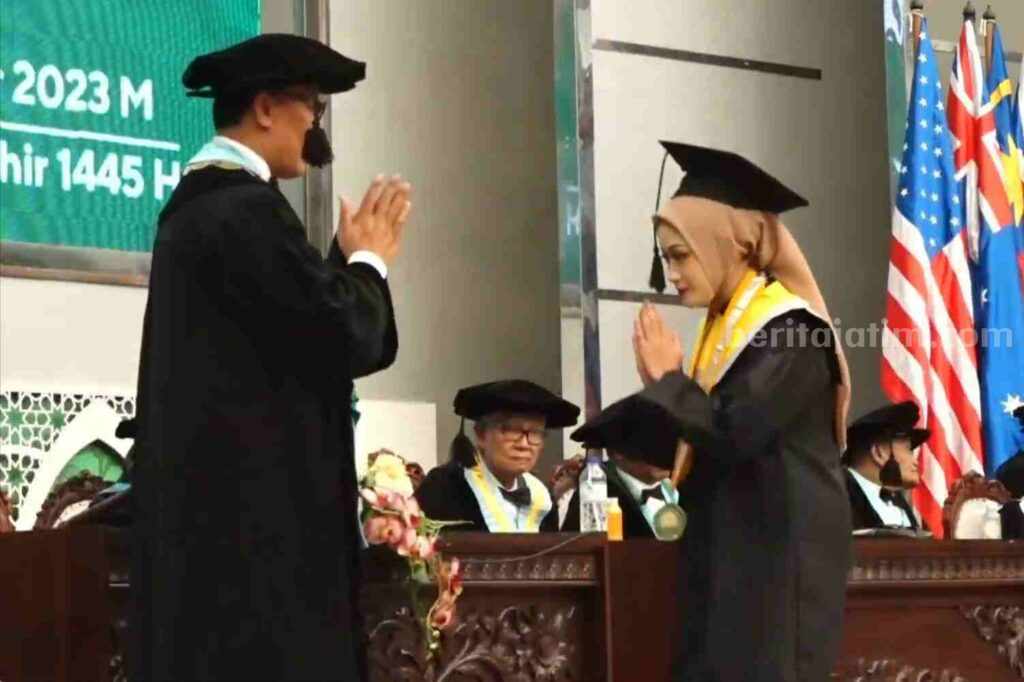 Rektor membaiat salah satu wisudawan dari Fakultas Ilmu Administrasi (Foto: Istimewa)