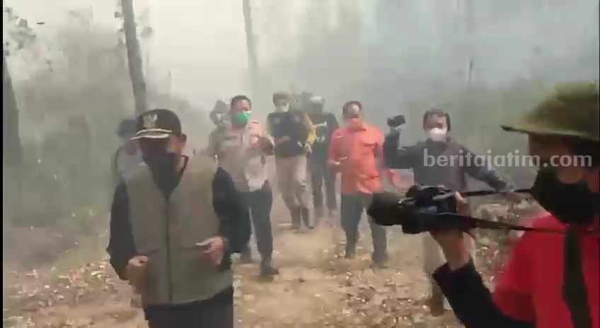 Bupati Ngawi Ony Datangkan Helikopter untuk Water Bombing Bupati Ngawi Ony Anwar Harsono beserta rombongan berlari menghindari api saat mengecek lokasi karhutla di Petak 19 RPH Banjaran, Kscamatan Sine, Ngawi, Minggu (1/10/2023).