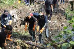 Pj Wali Kota Malang Mudun Kali Bersihkan Sampah Sungai Gandeng Komunitas Lingkungan Pj Wali Kota Malang, Wahyu Hidayat saat membersihkan sampah di sungai.