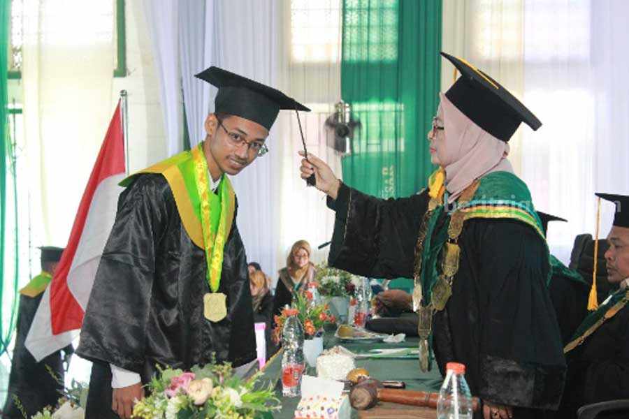 Rektor memindahkan toga kepada salah satu wisudawan Program Sarjana Strata Satu XIV, Institut Agama Islam Tarbiyatut Tholabah (IAI TABAH) Lamongan.