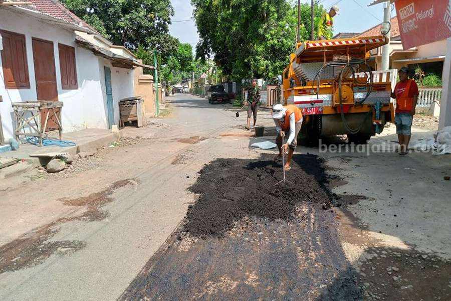 Sejumlah petugas perbaikan jalan saat menambal sejumlah jalan di Kecamatan Sumber Asih.