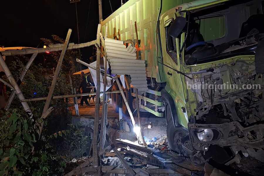Caption : Petugas Unit Laka Satlantas Polres Mojokerto mengevakuasi bangkai dump truk nopol N 9533 UV tersangkut di perlintasan kereta api tanpa palang pintu di Dusun Damarsih, Desa Kepuhanyar, Kecamatan Mojoanyar, Kabupaten Mojoanyar, Kabupaten Mojokerto. [Foto : Misti/beritajatim.com]