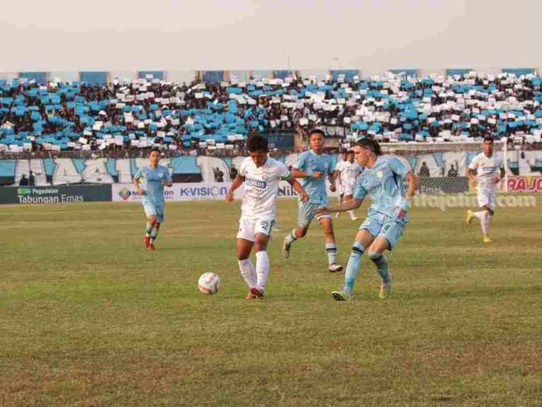 Foto pemain Gresik United (kiri) dibayangi pemain Persela di laga putaran pertama
