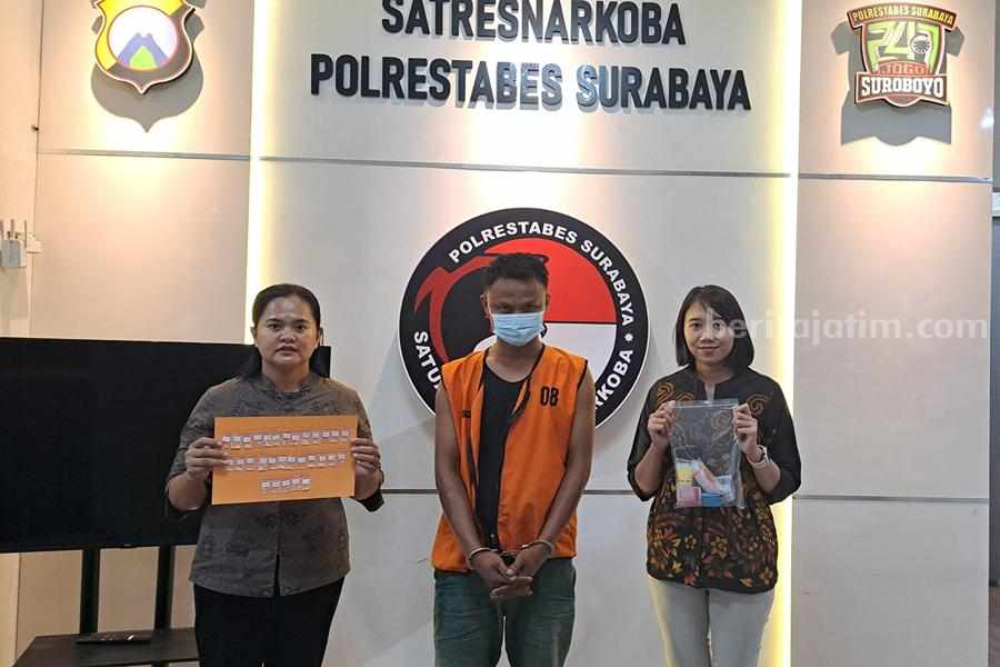 MD saat diapit dua petugas Satres Narkoba Polrestabes Surabaya.