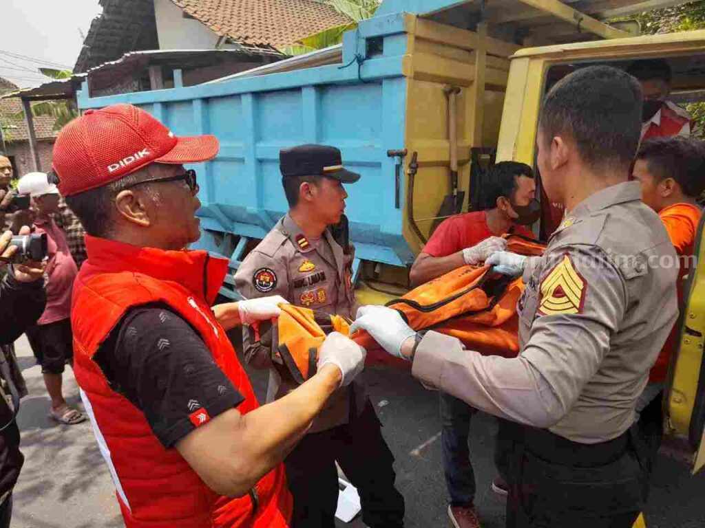 Ps Kapolsek Dlanggu, Iptu Mohammad Khoirul Umam bersama sejumlah relawan mengevakuasi jenazah korban. [Foto : ist]