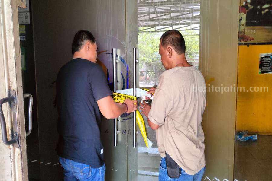 Petugas saat memasang garis police line di pintu Phoenix Club Surabaya usai terjadi penusukan yang menyebabkan warga Sampang tewas. (Foto/Anggadia)